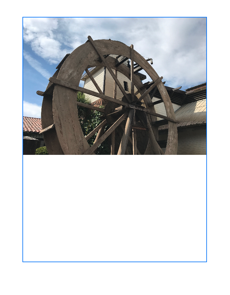 An image that shows a frame with a blue border overlaid on an image of a water wheel. The water wheel image is scaled to fit the width of the containing rectangle. Empty space extends from the bottom of the image to the bottom of the rectangle.